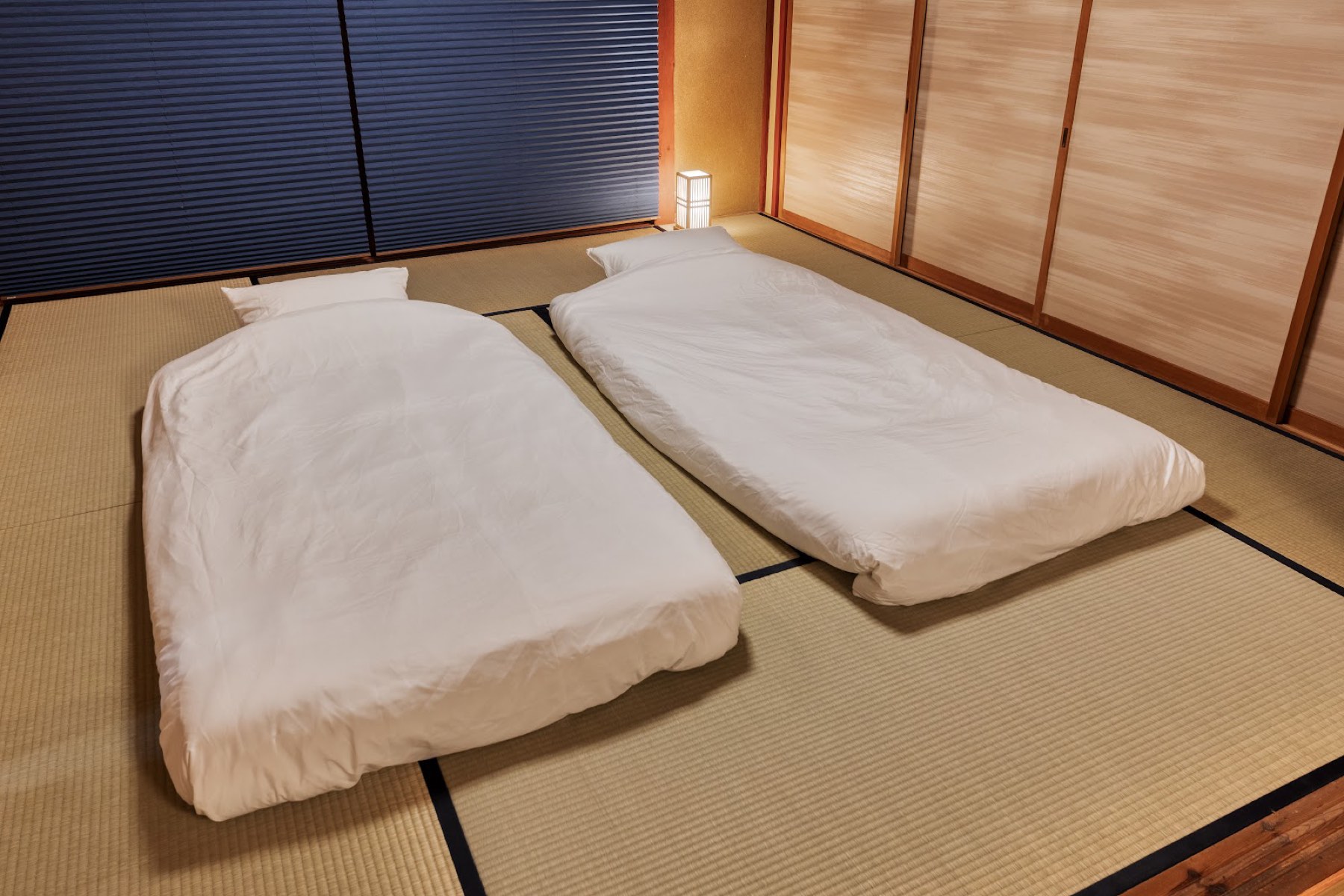 畳の和室に二組の布団が並べて敷かれている