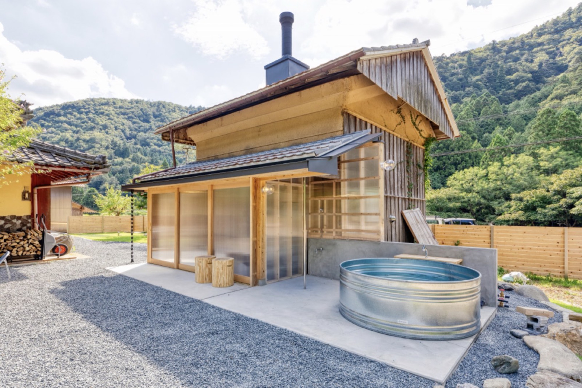 蔵を改装したサウナの外観と、屋外に置かれた金属製の水風呂